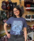 Woman wearing a t-shirt with 'Weird Sisters' chimera design in a yarn store.