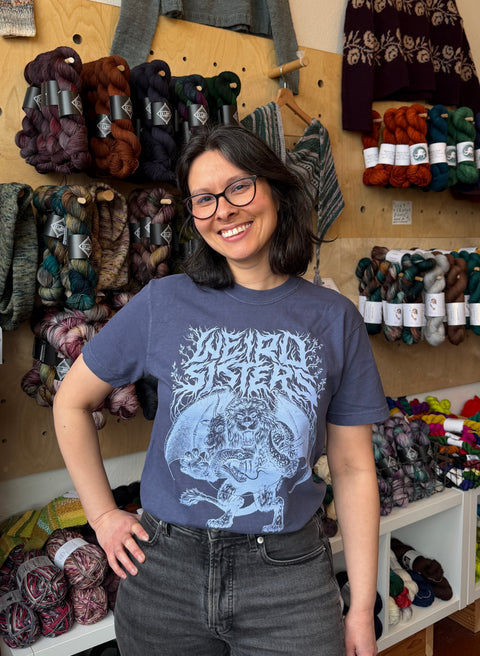 Woman wearing a t-shirt with 'Weird Sisters' chimera design in a yarn store.