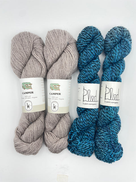 Three skeins of yarn, two blue and one gray, with labels on a white background.
